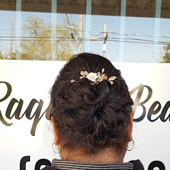 A woman's updo hairstyle with a small flower